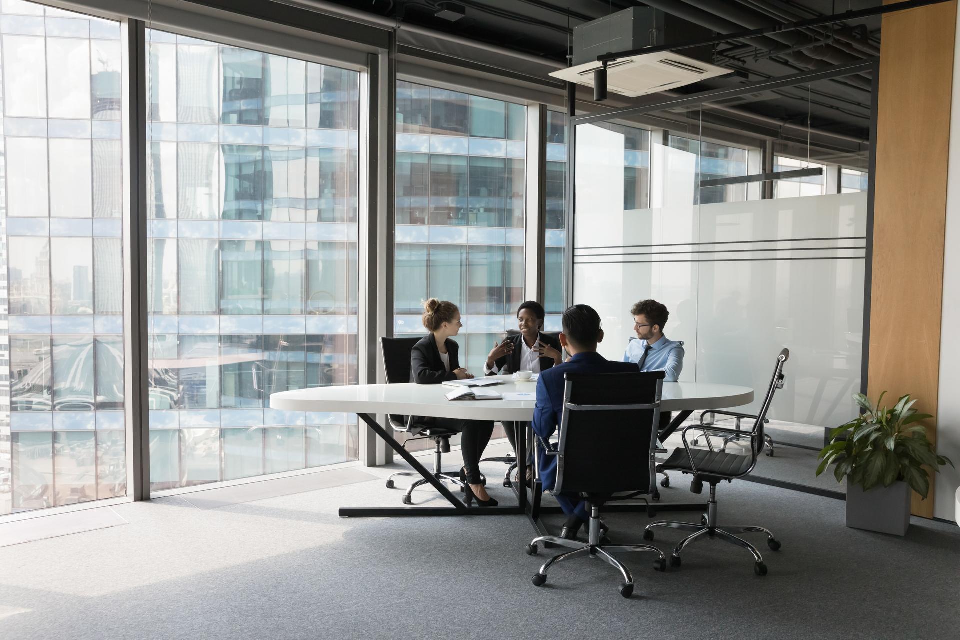 Diverse millennial business team talking in meeting room